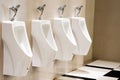 Urinals in modern public menÃ¢â¬â¢s toilet interior with white ceramic urinals. Royalty Free Stock Photo